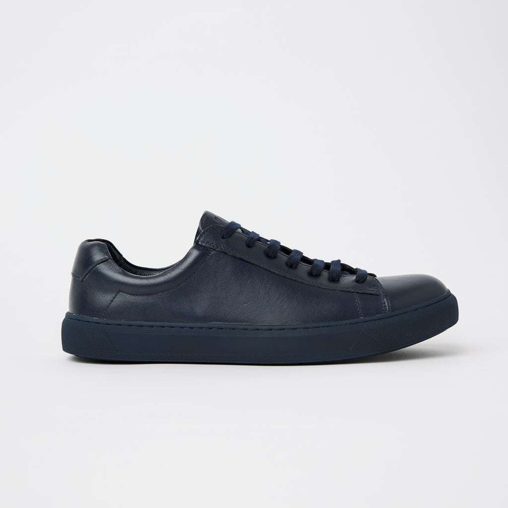 the mens leather dress sneaker on the side in a deep navy colour