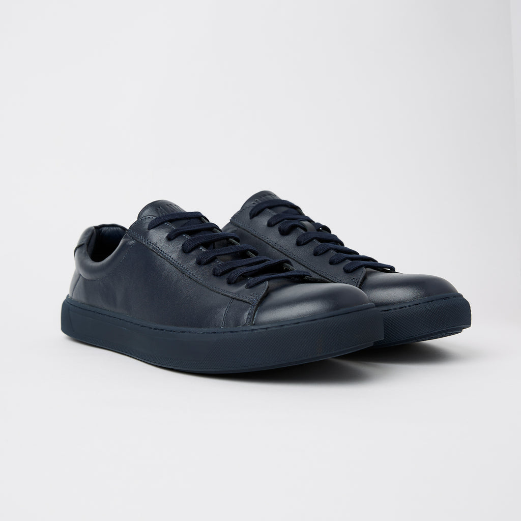 a pair of blue navy mens leather sneakers 