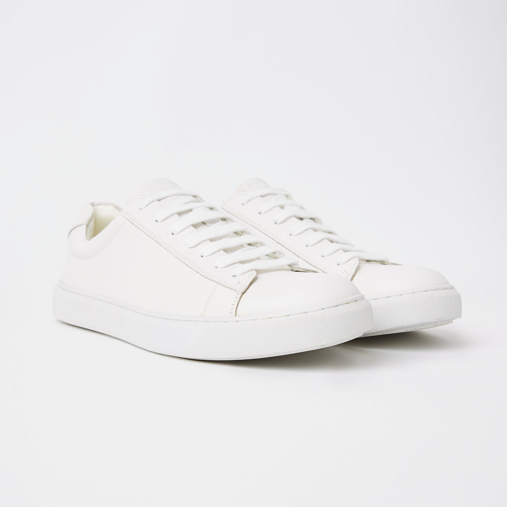 white mens leather sneakers on the side showing the sole